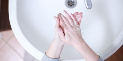 women washing hands in bathroom sink